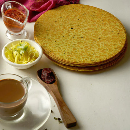 Maniarr's Masala Khakhra presented on a plate, surrounded by fresh spices, emphasizing natural ingredients.